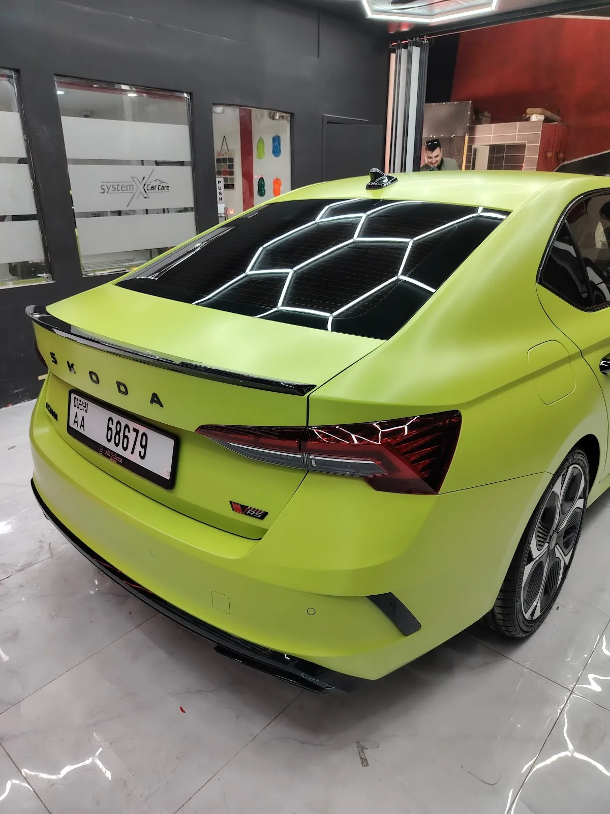 A car finished in a lime-green vinyl wrap at System X Car Care