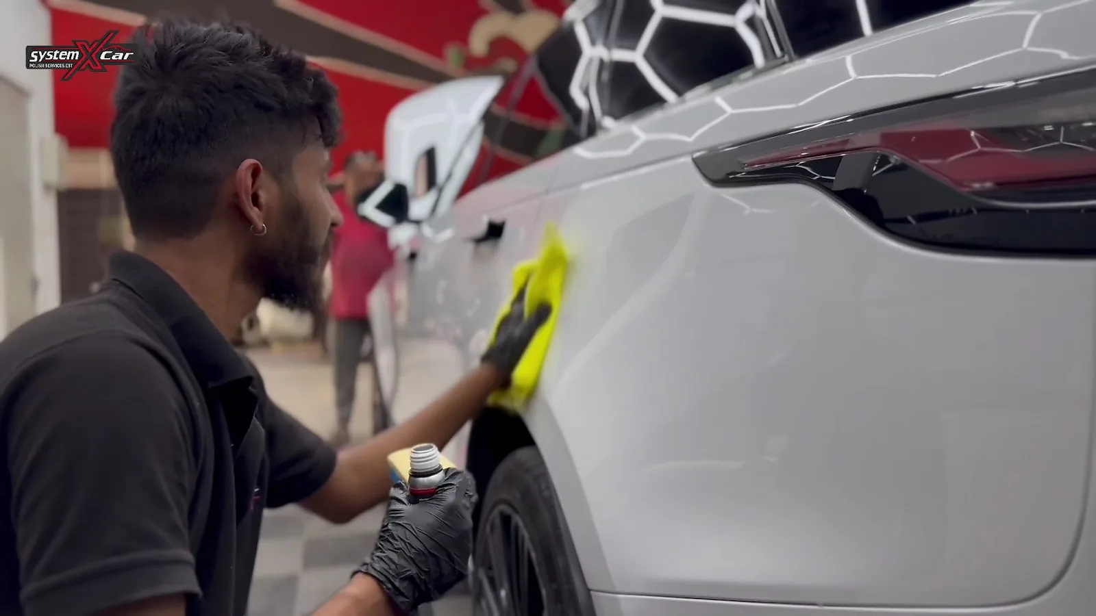 A technician wiping down a freshly coated panel