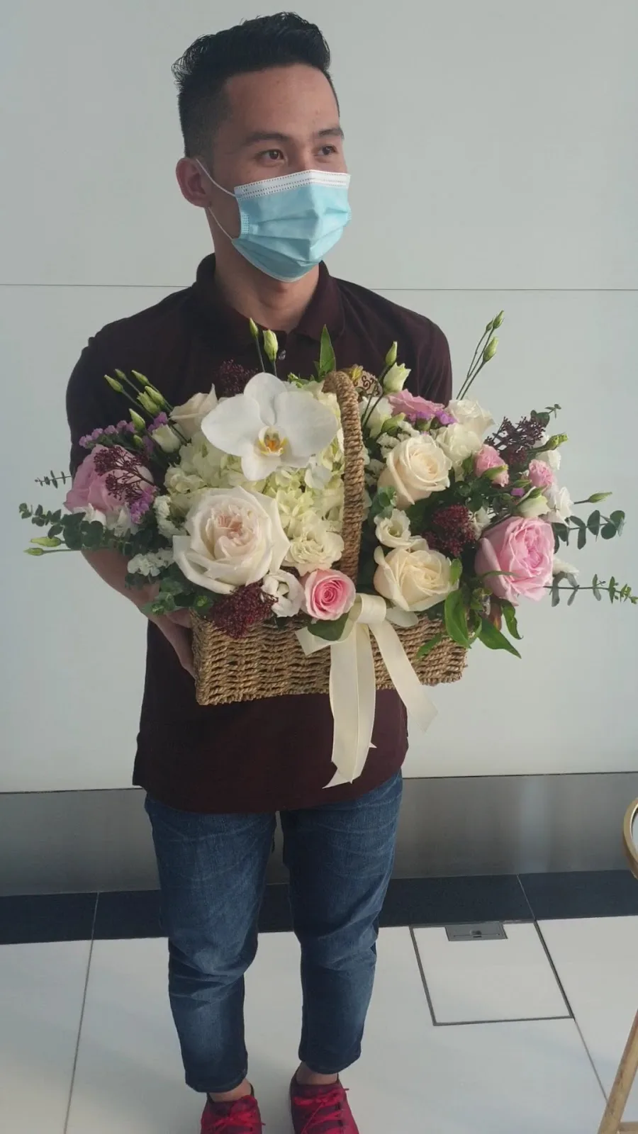 Woven basket of mixed seasonal roses and orchids