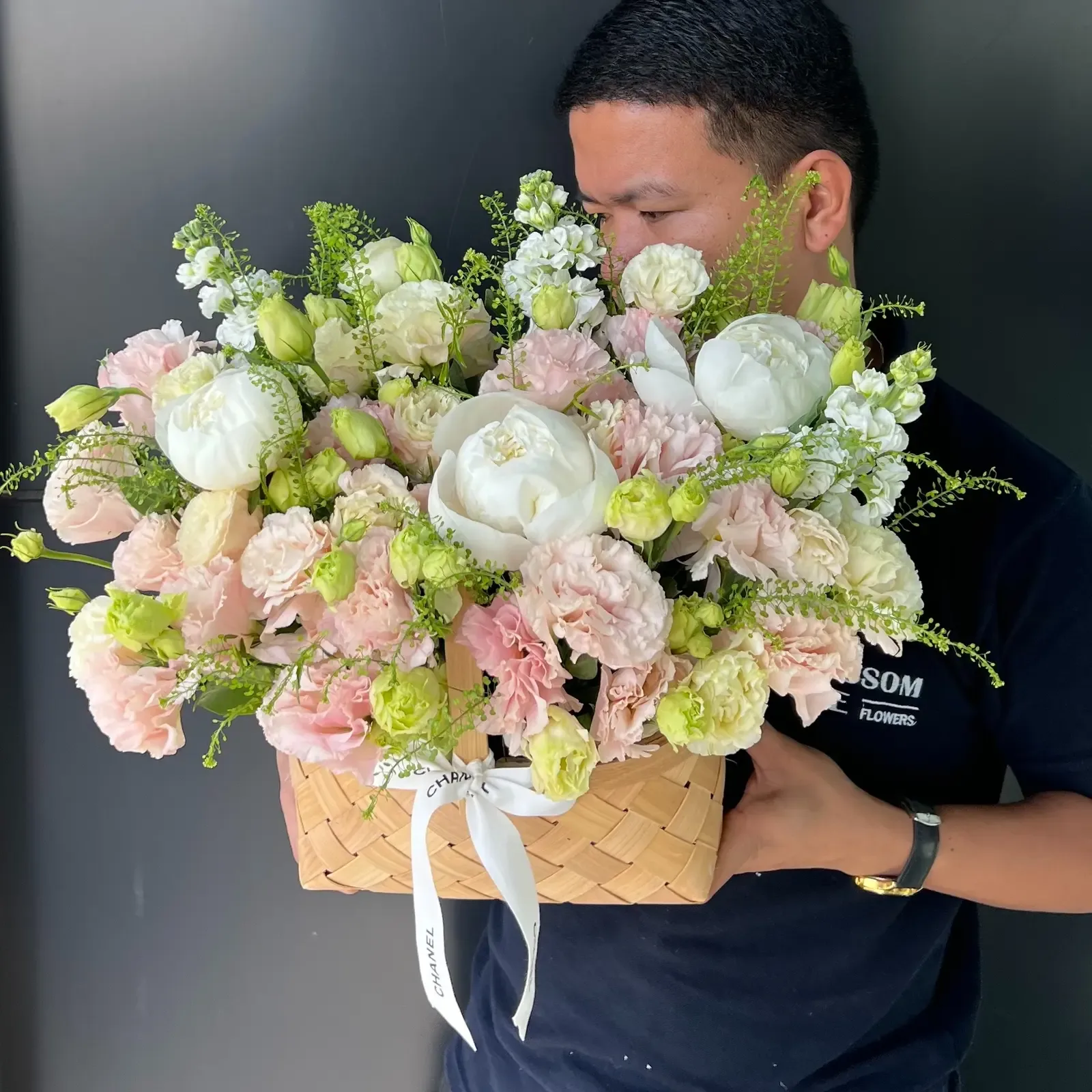 Woven basket of soft pastel peonies and carnations