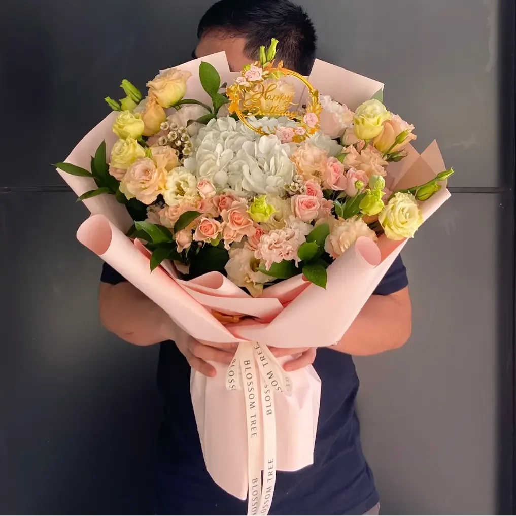 Peach and cream birthday bouquet with a Happy Birthday topper