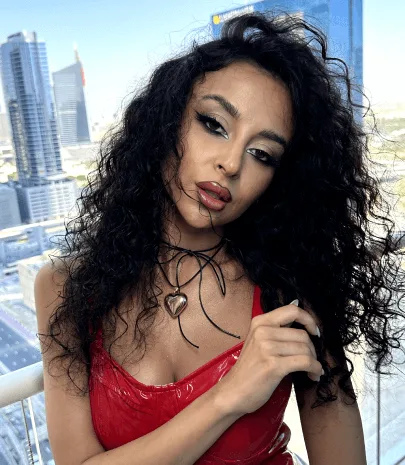 Salon client with styled hair and evening makeup against a Dubai Marina skyline