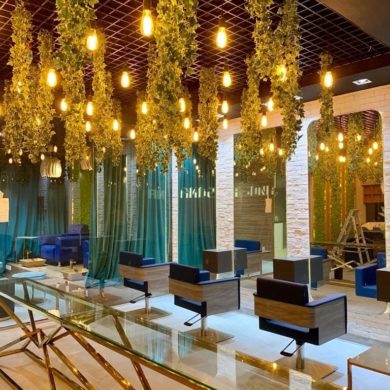 Salon interior with hanging greenery and warm Edison lighting