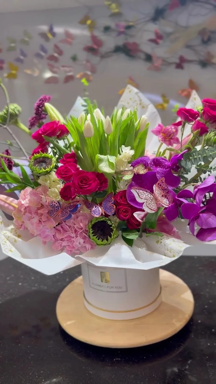 Colourful flower box with roses, tulips, orchids and butterfly accents