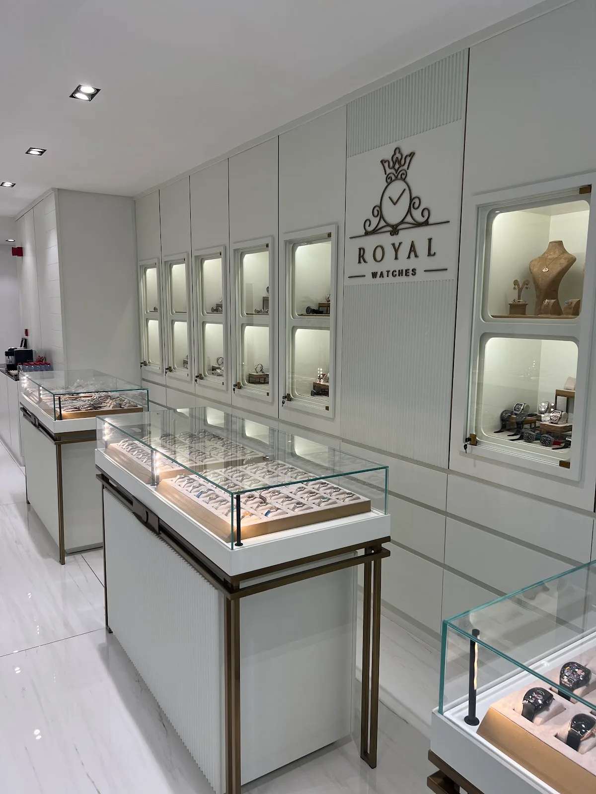 Bright showroom interior with the Royal Watches crest on the wall and lit display cabinets