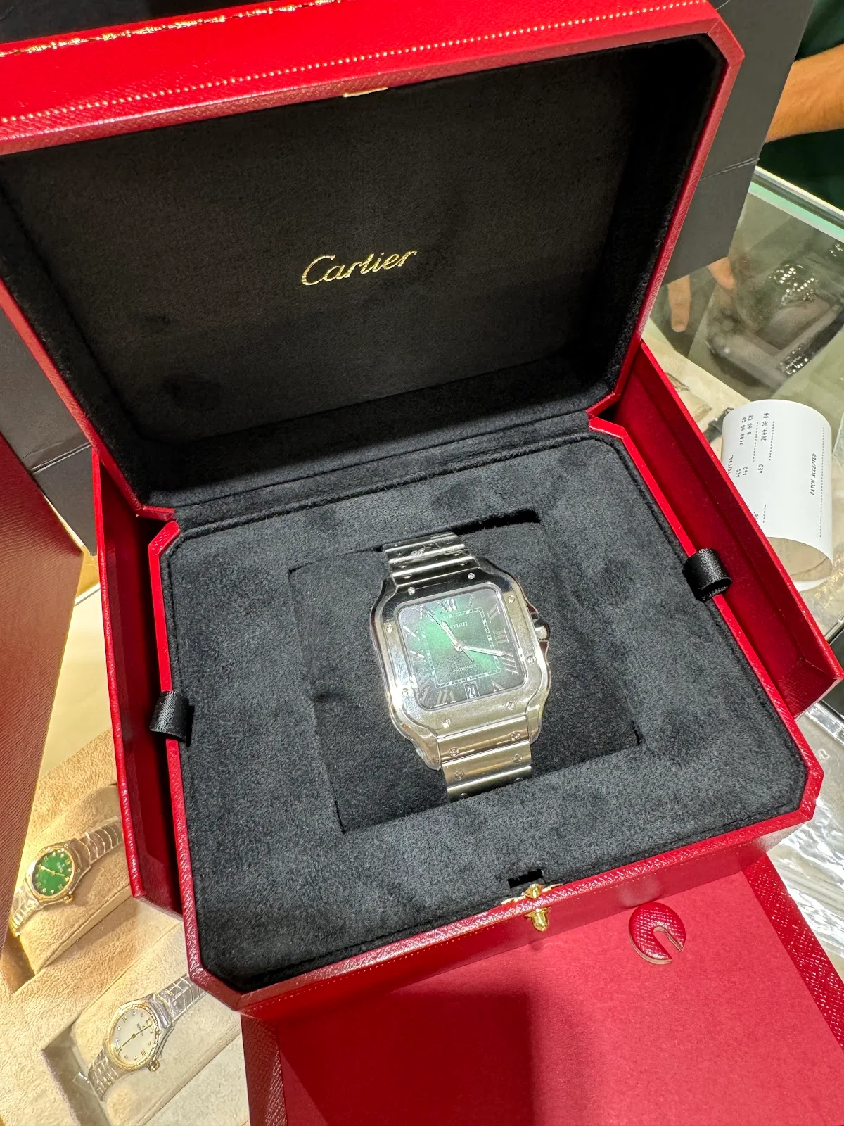 A steel Cartier watch presented in its red box