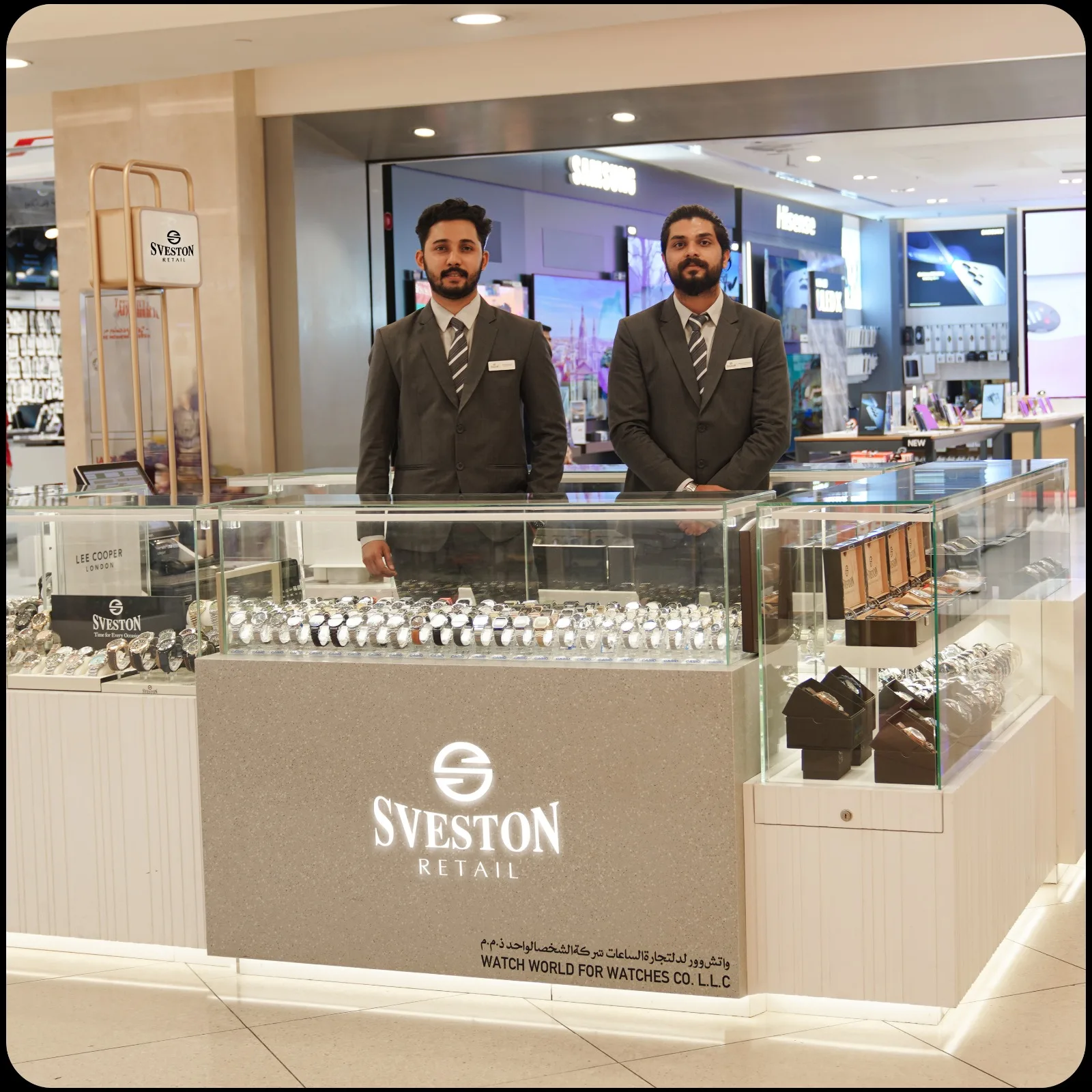 Two staff members behind the lit SVESTON Retail watch counter