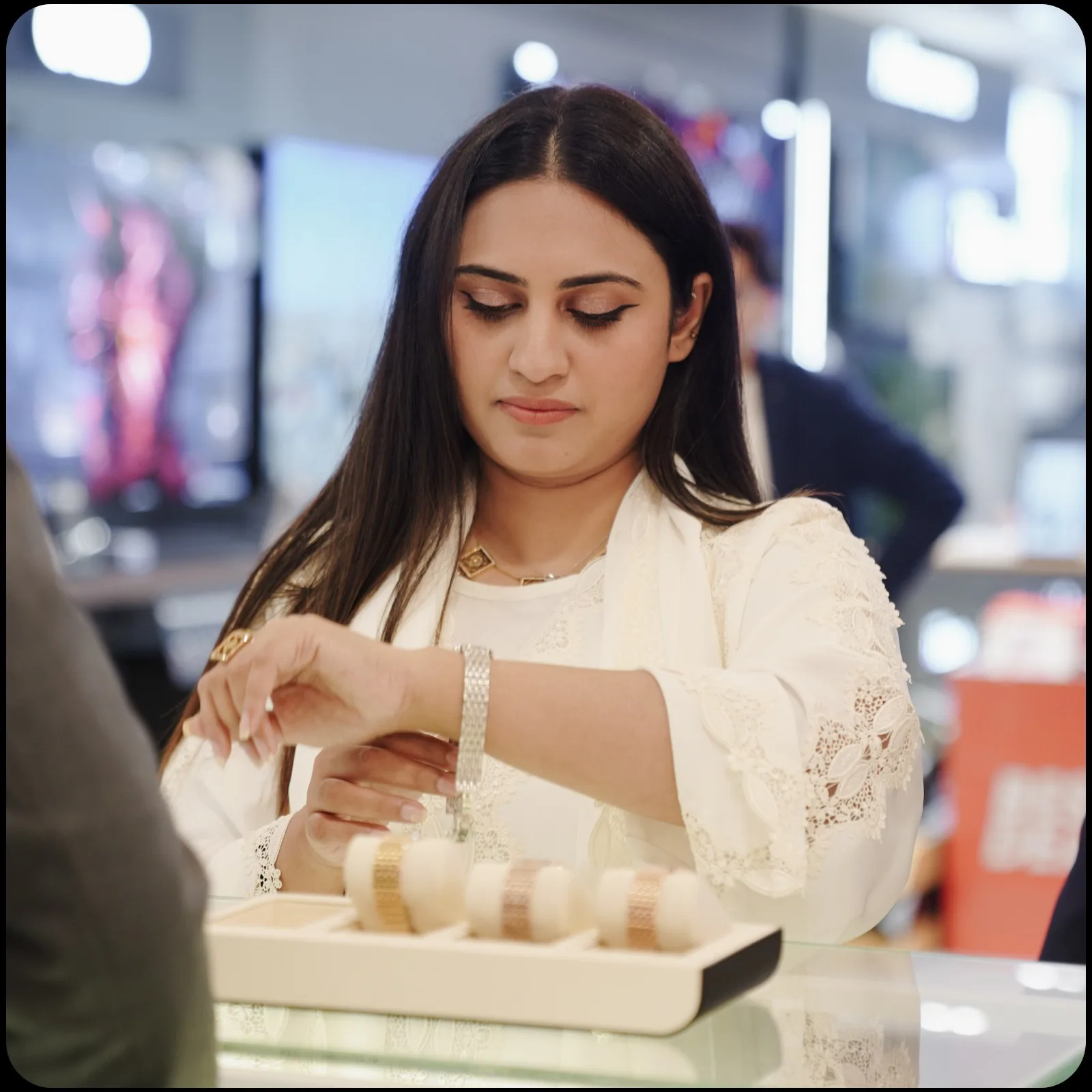 A customer trying on a bracelet watch at the counter