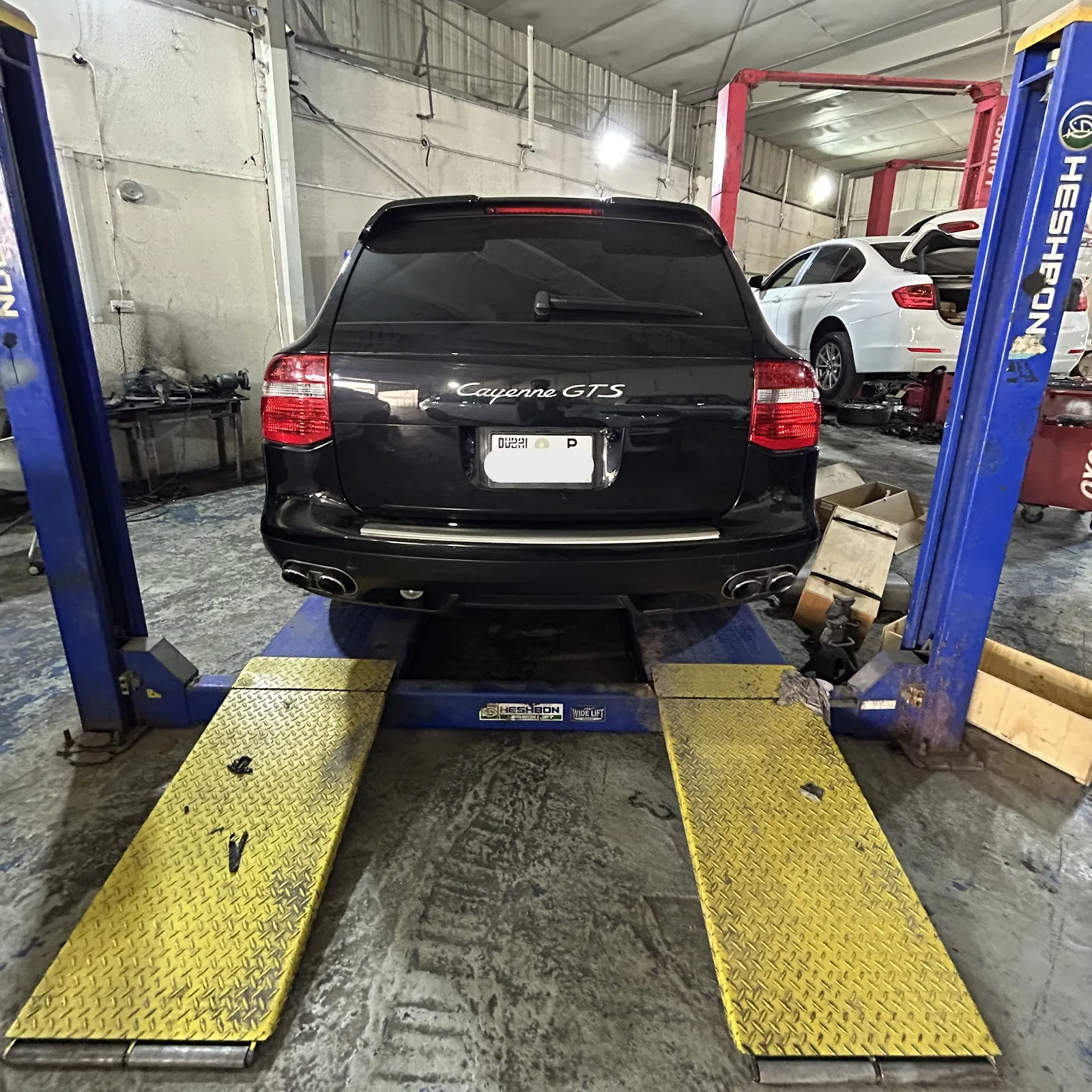 SUV raised on a four-post lift in the workshop