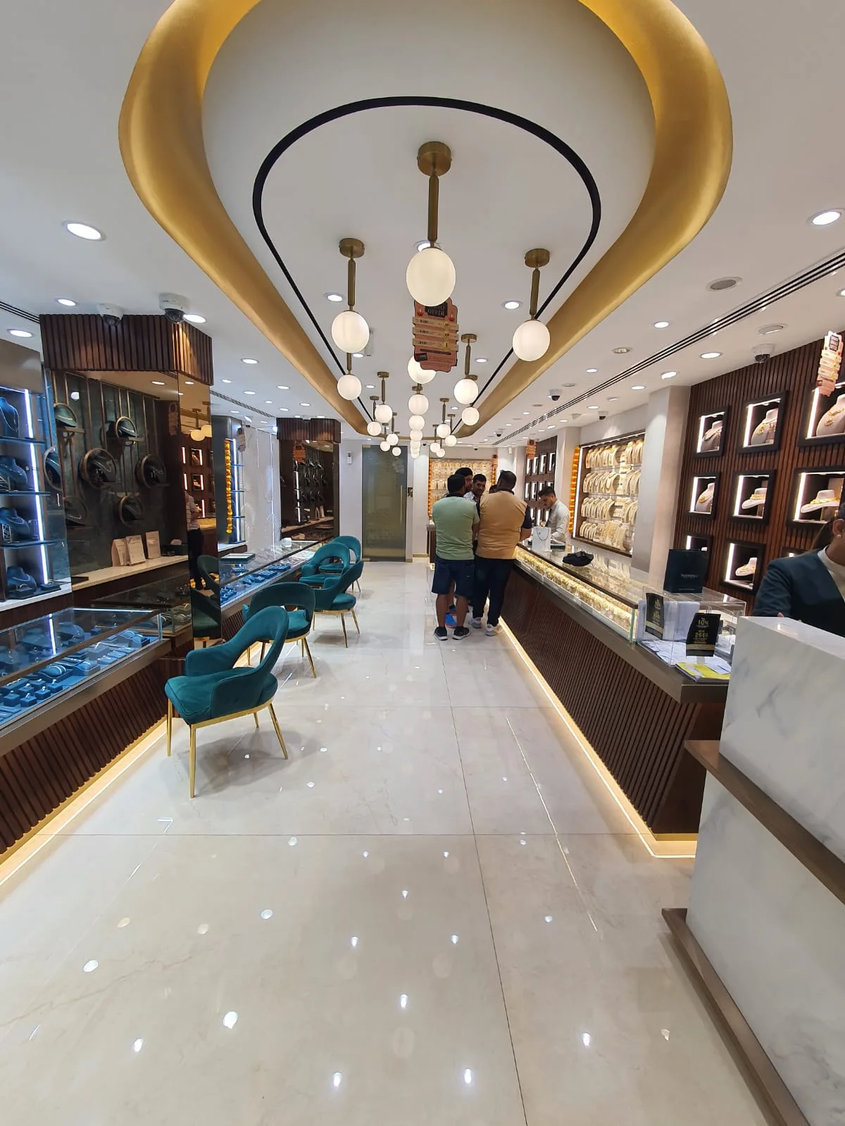Interior of the Thangals showroom with display cabinets, teal chairs and pendant lighting