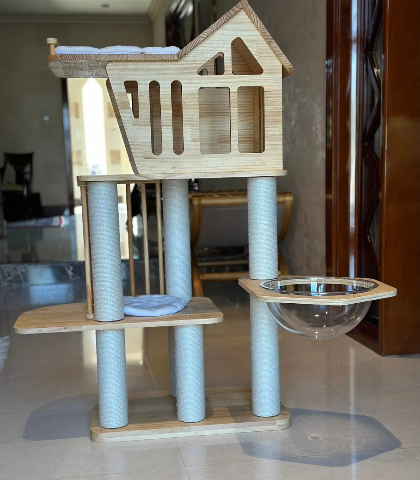 A handcrafted wooden cat tower with a house and bowl