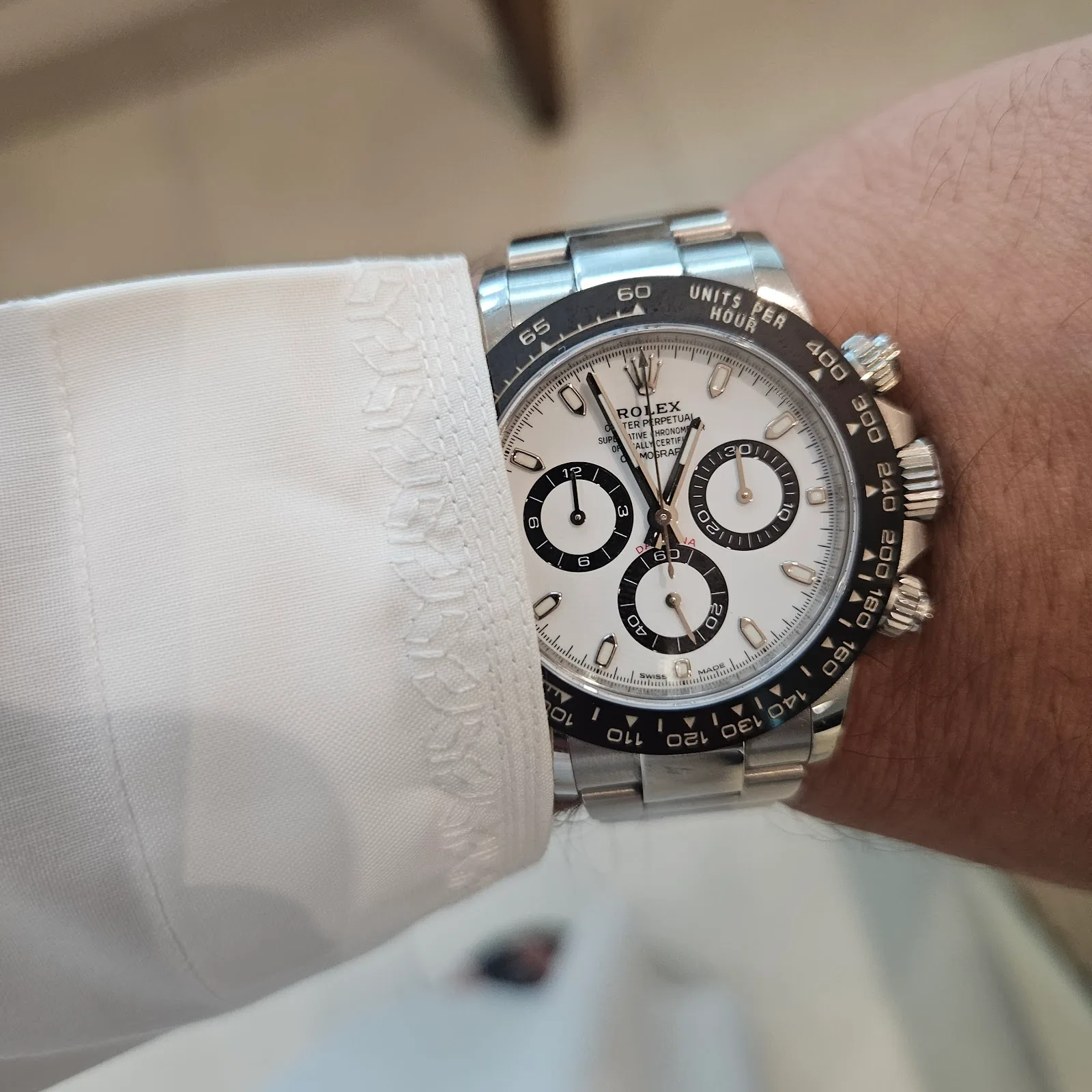 A chronograph watch worn on the wrist beneath a shirt cuff