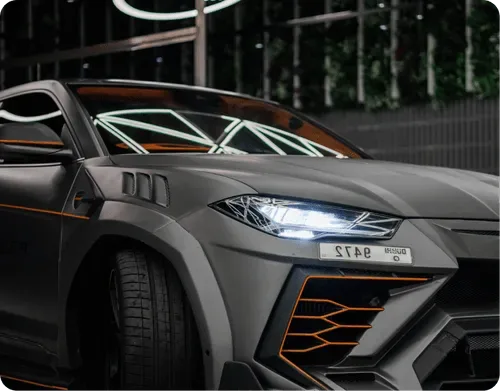 A widebody Lamborghini Urus with orange accents and body styling