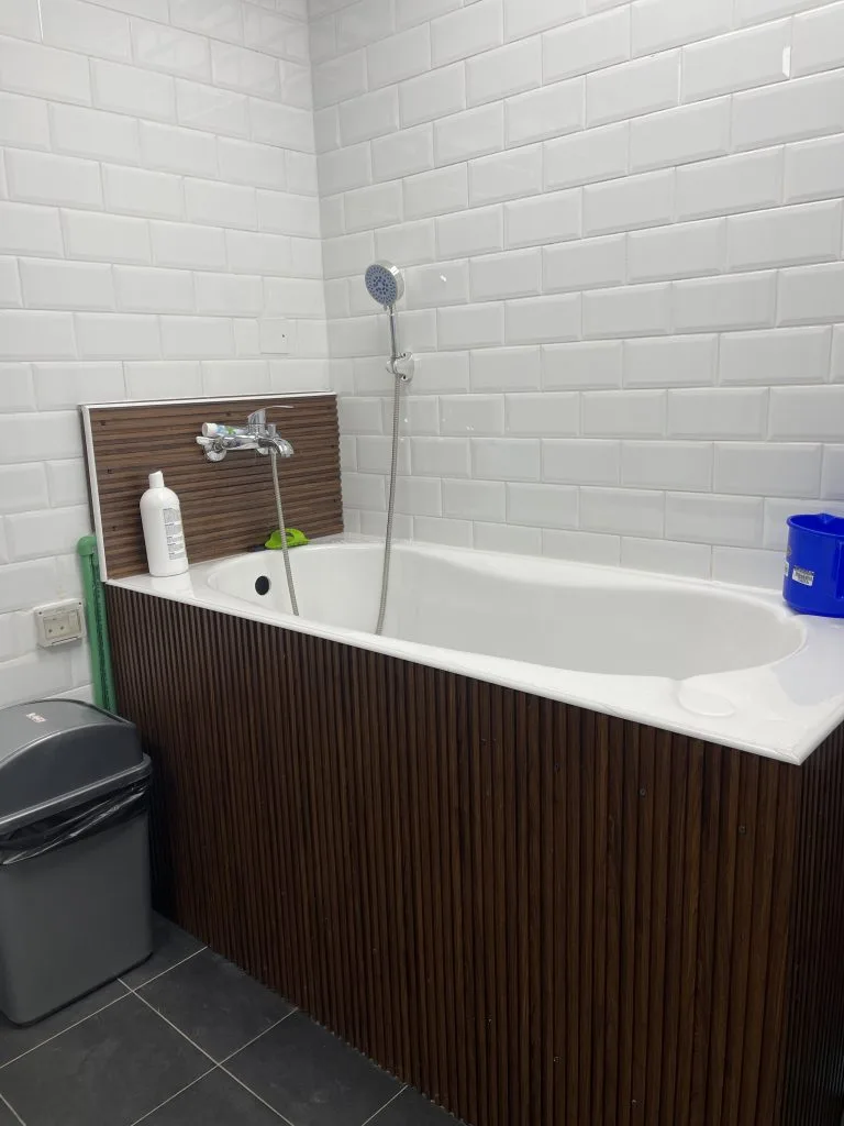Clean, tiled bathing station with handheld shower for dogs and cats