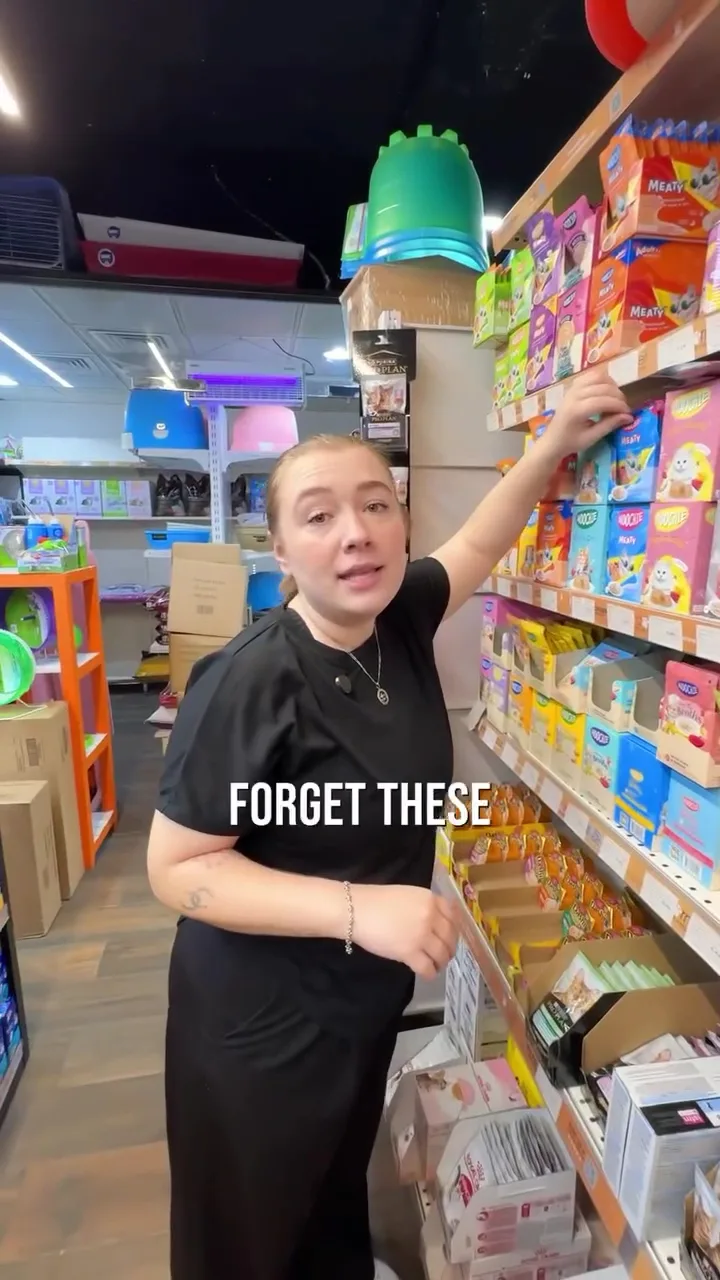 Team member arranging shelves of cat treats in store