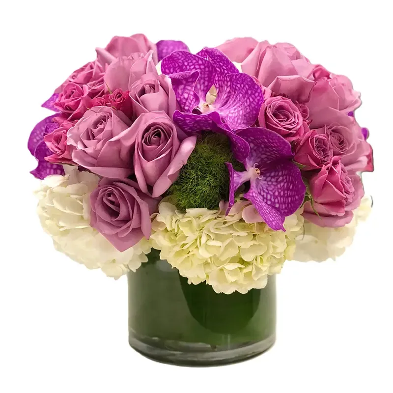 Lavender roses with hydrangea and an orchid accent in a glass vase