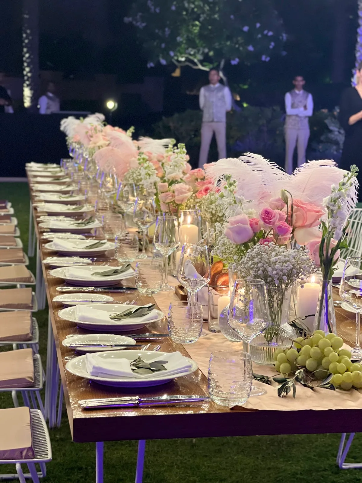 Evening event table with pink florals and feather accents