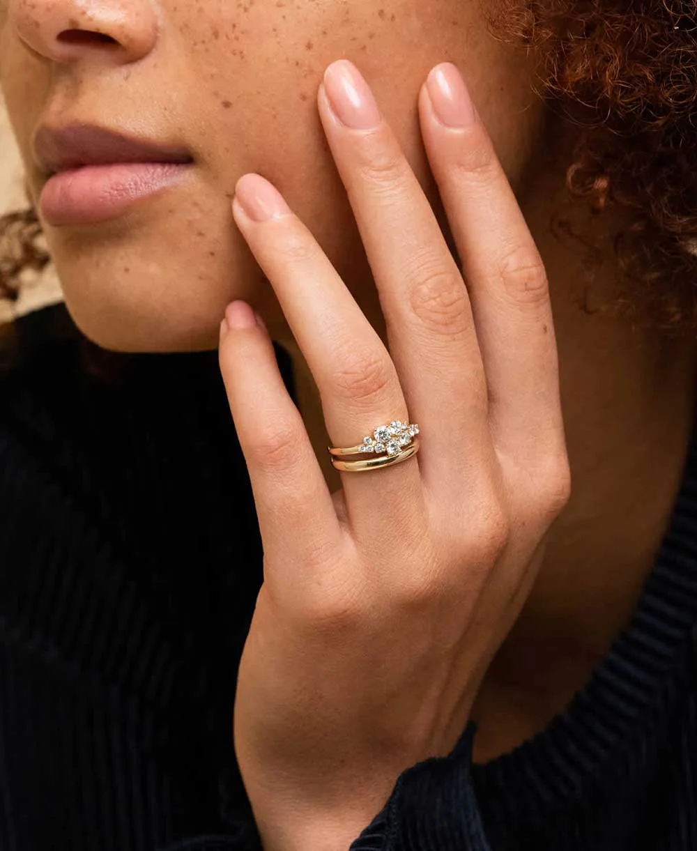 A hand wearing a Beladamaz diamond engagement ring in yellow gold