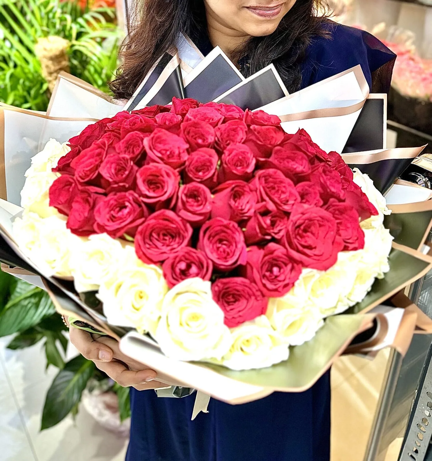 Large round bouquet of red and white roses held in the shop