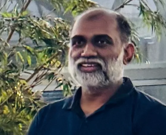 The owner of Lucky Flowers standing among greenery