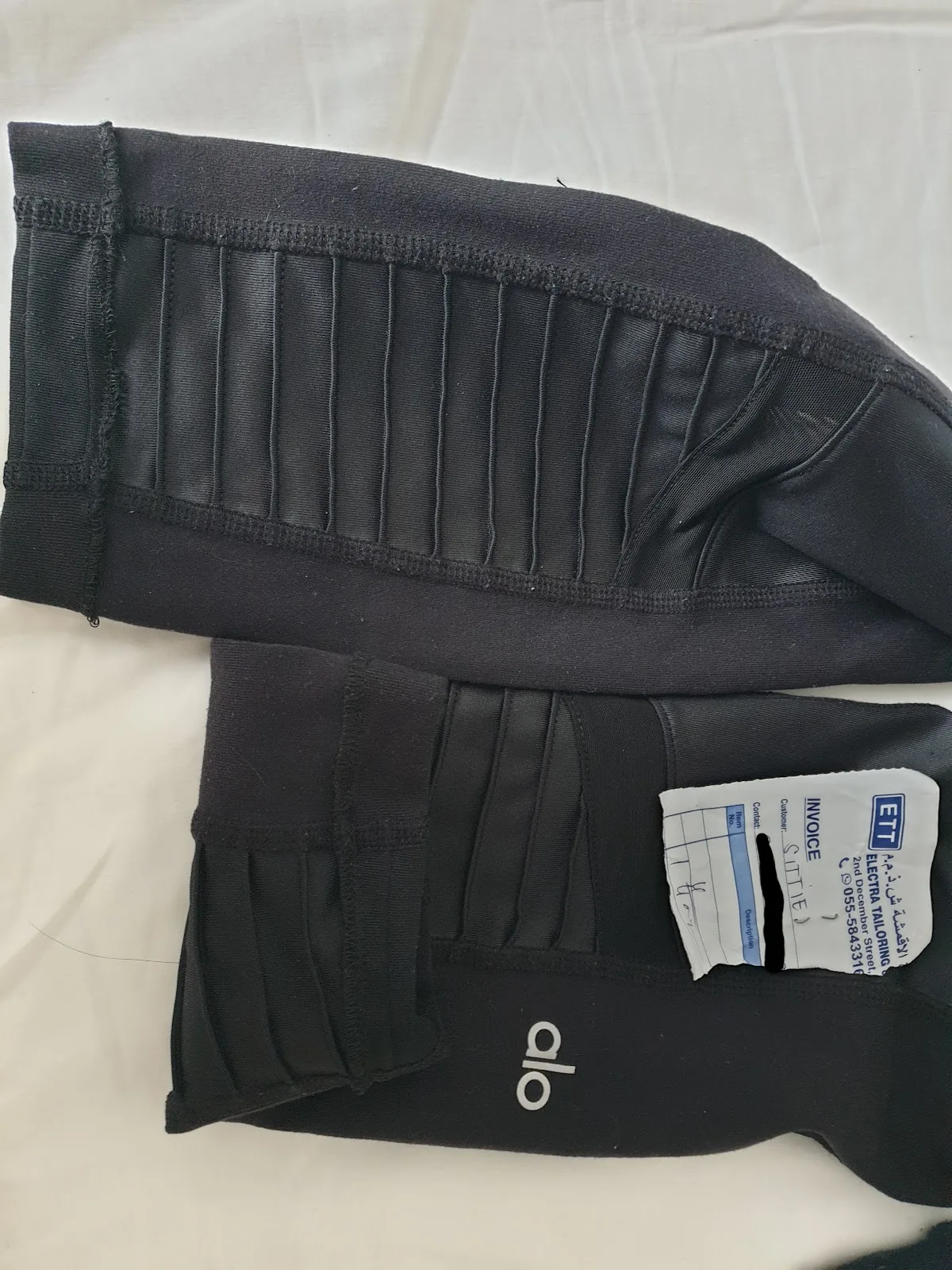 Black leggings re-hemmed and tapered, tagged with an Electra Tailoring invoice slip.
