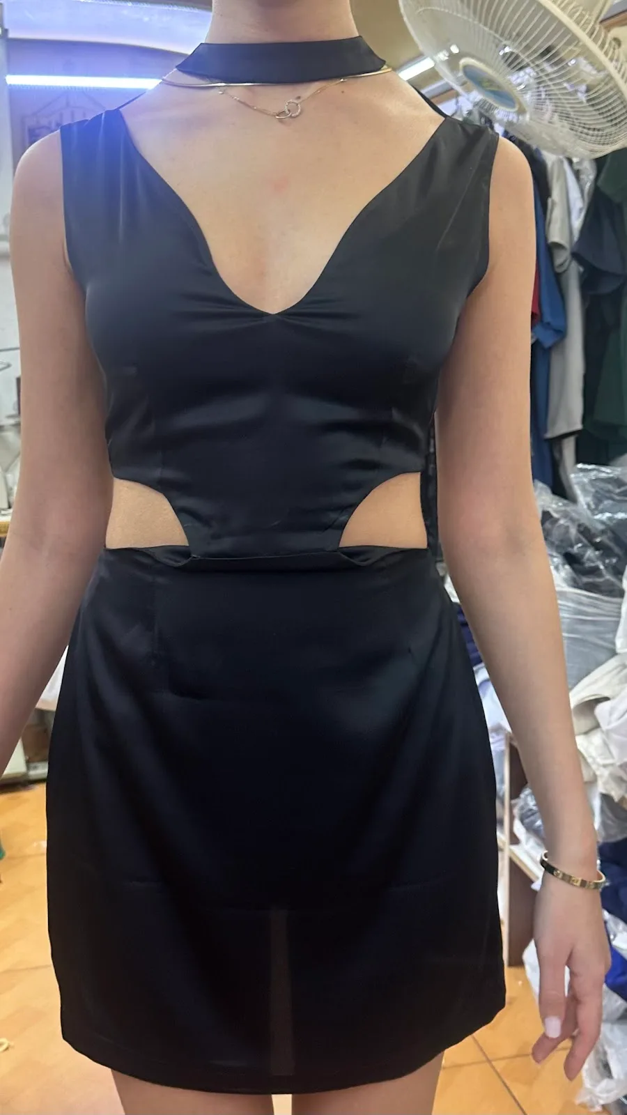 Black satin mini dress with a cut-out waist and choker neckline.