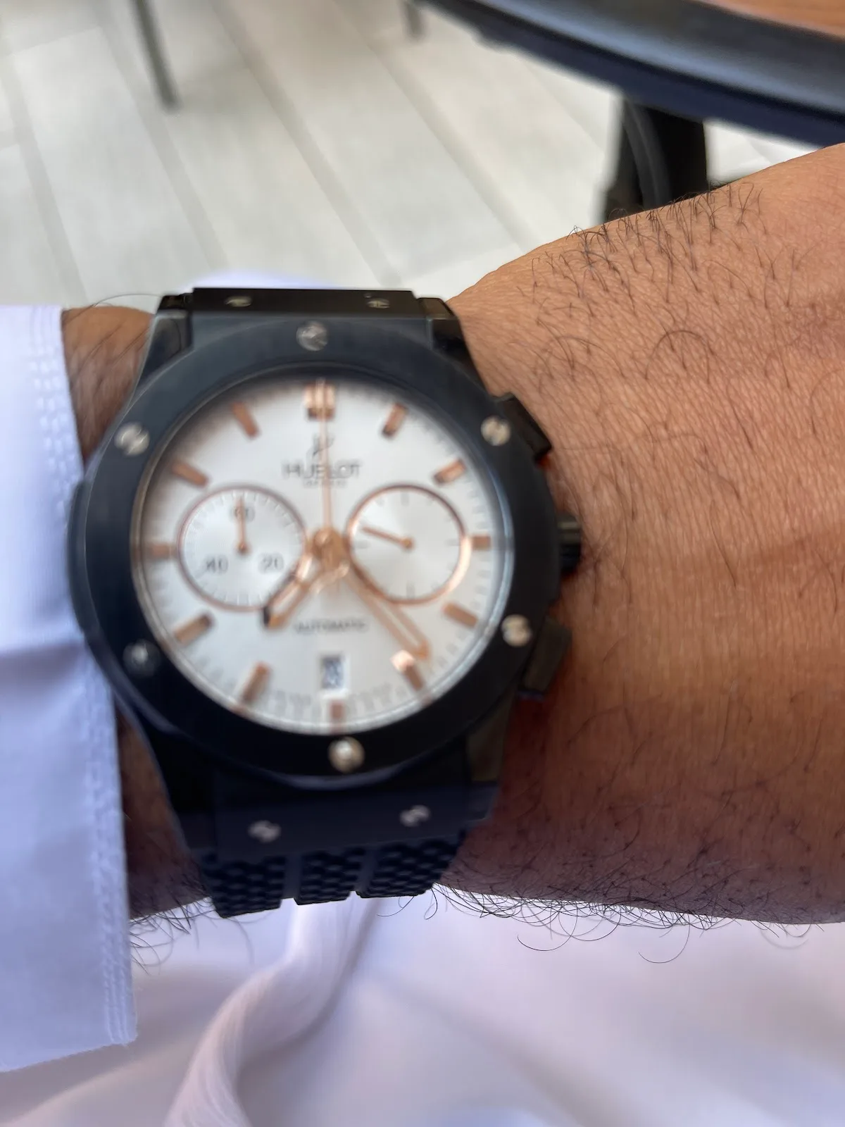 Black ceramic chronograph with rose-gold accents on the wrist