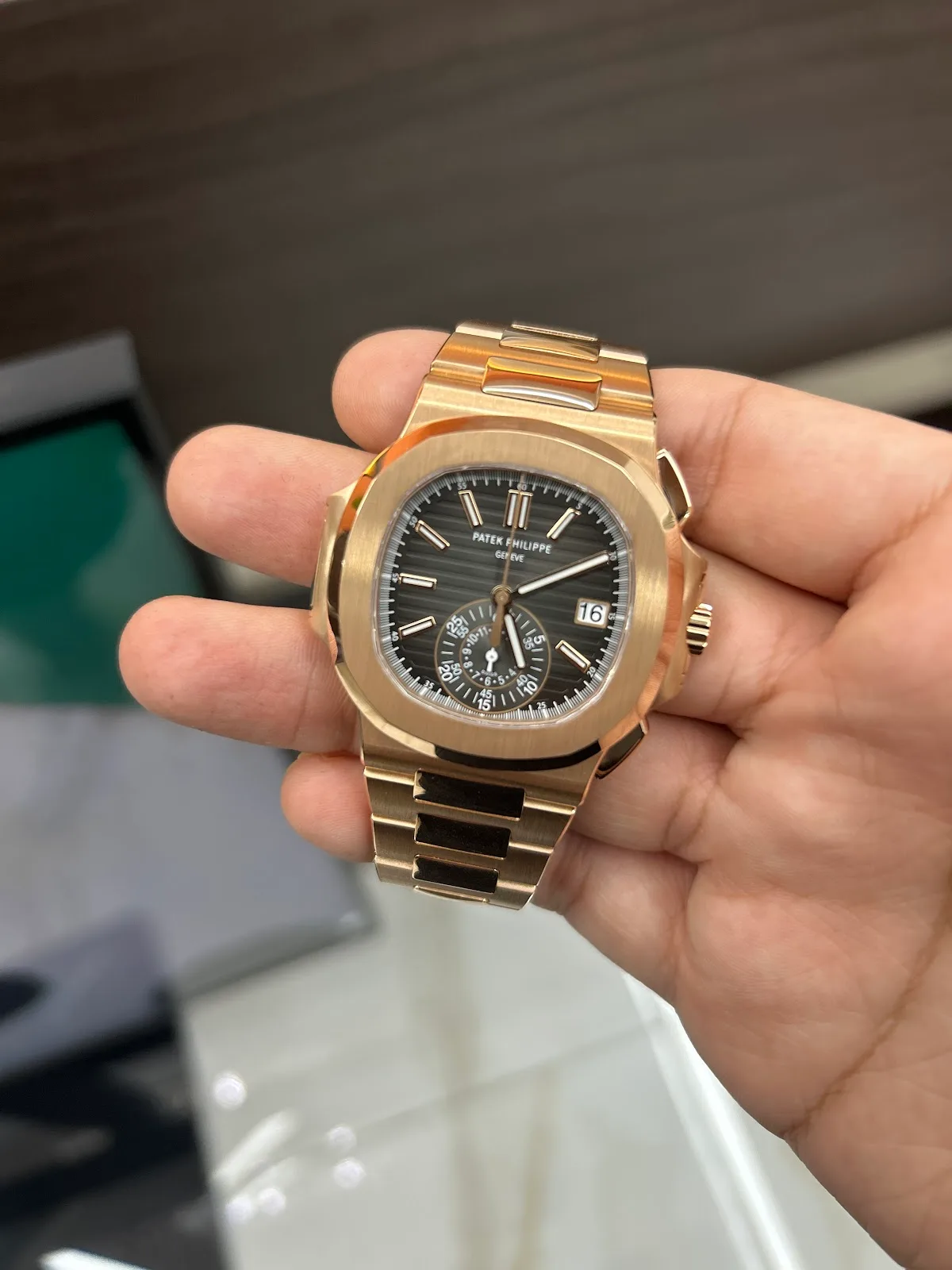 Rose-gold chronograph held in hand