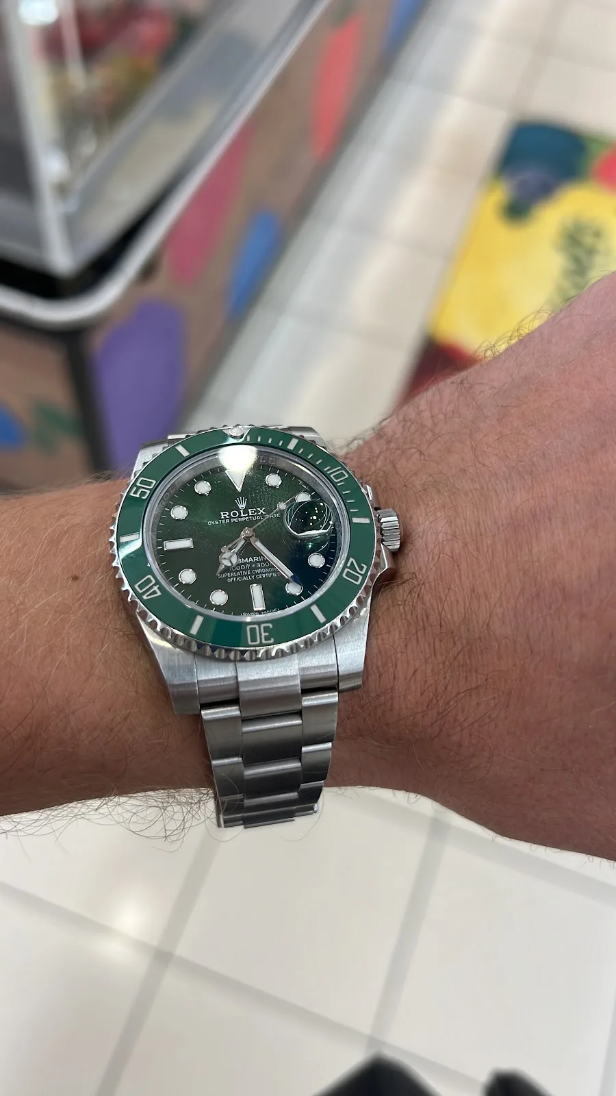A serviced green-bezel steel diving watch on the wrist