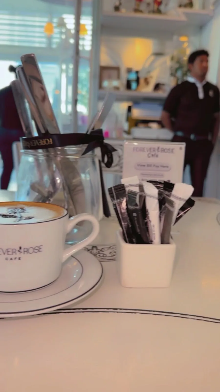 A Forever Rose Café cup and saucer set on a marble table