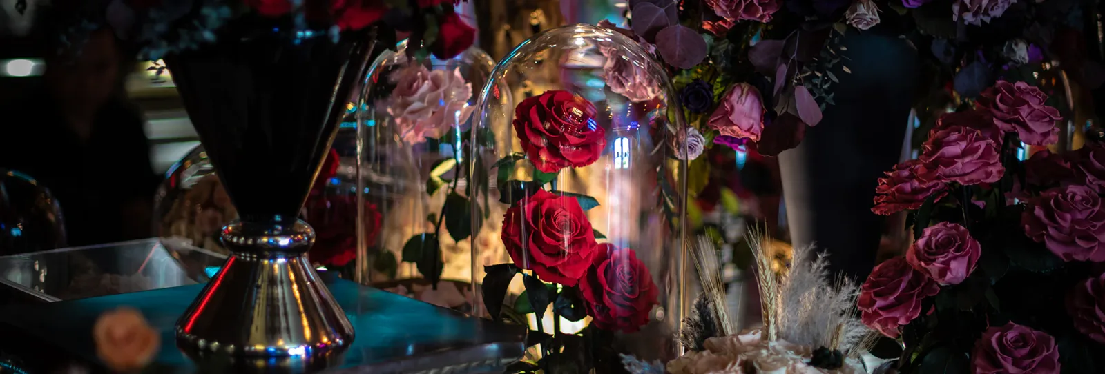 Red preserved roses displayed under glass domes