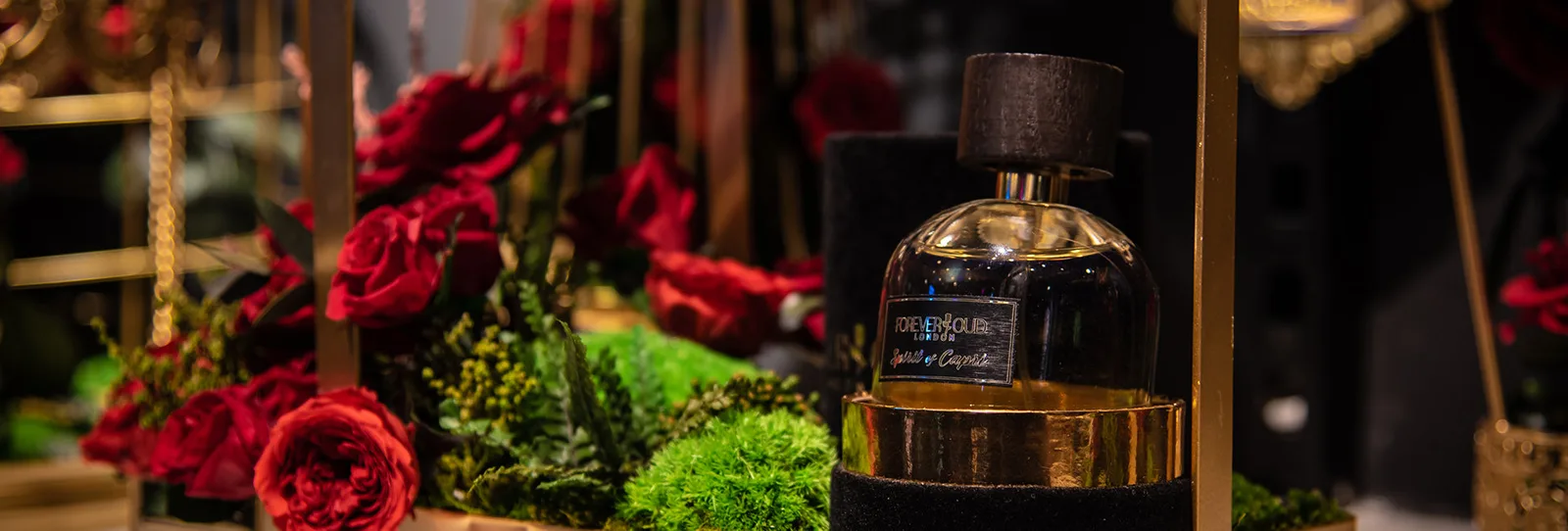 Forever Oud London fragrance bottle among red roses