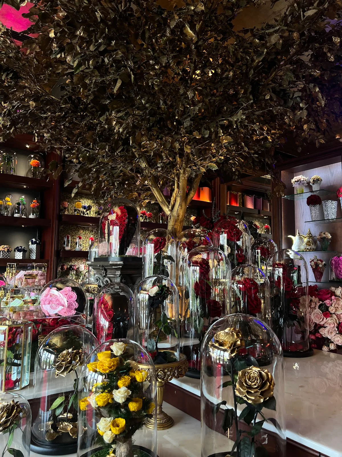 A red British phone box surrounded by fresh flowers and velvet chairs