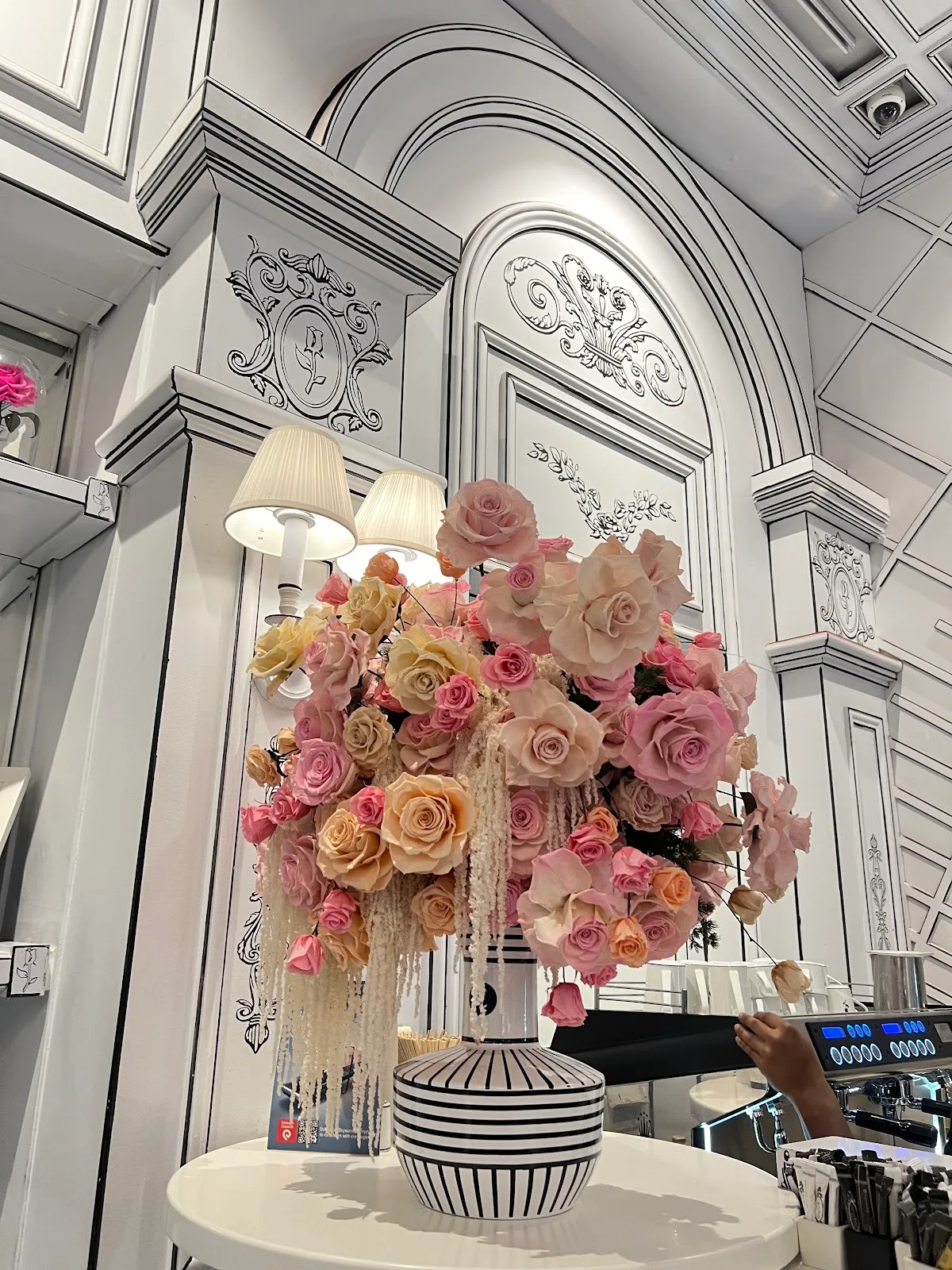 A framed tribute portrait displayed in the atelier surrounded by flowers