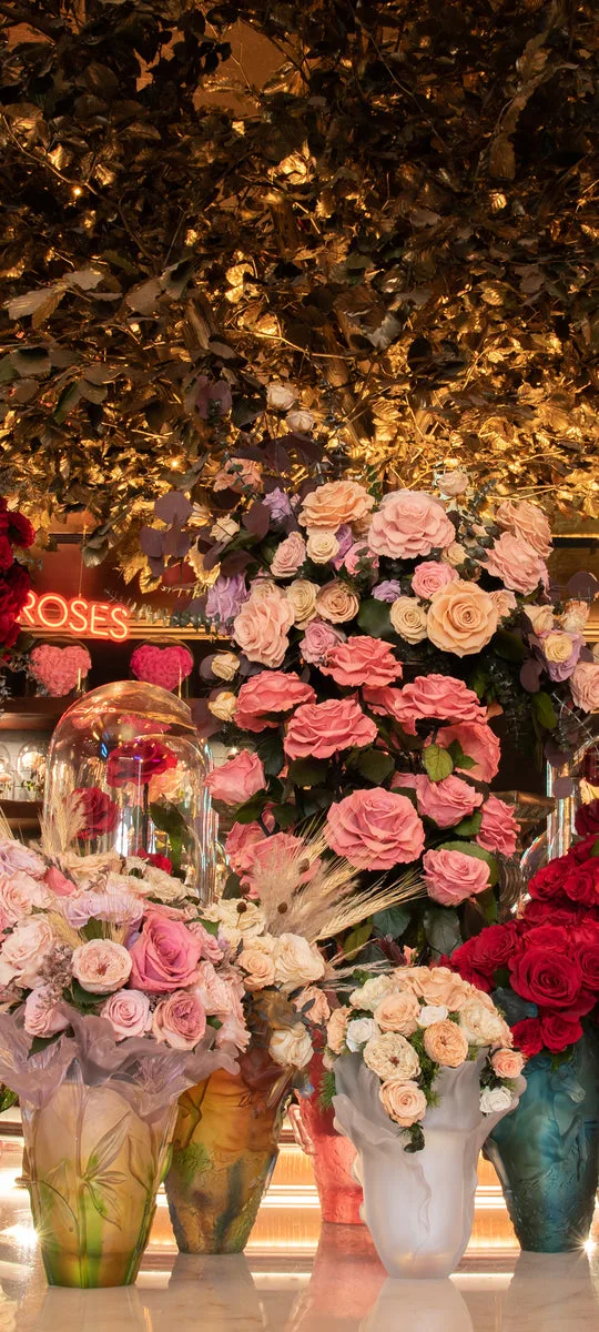 Soft pink and peach roses beneath the gilded ceiling of the atelier