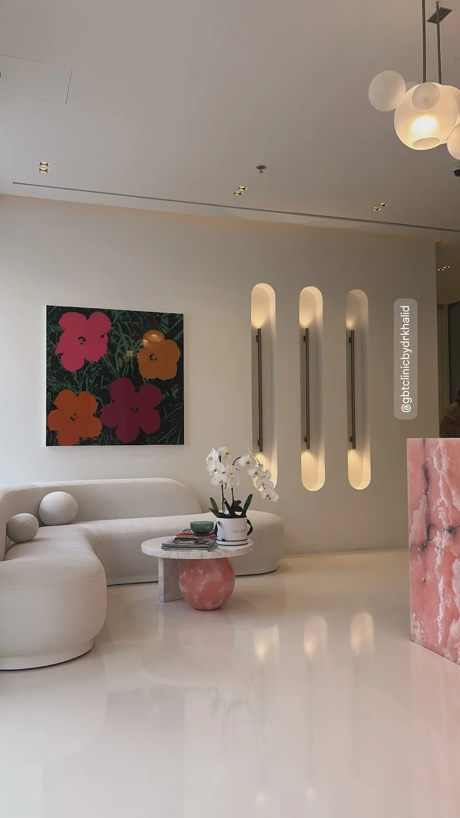 Curved white lounge seating beneath a colourful pop-art canvas