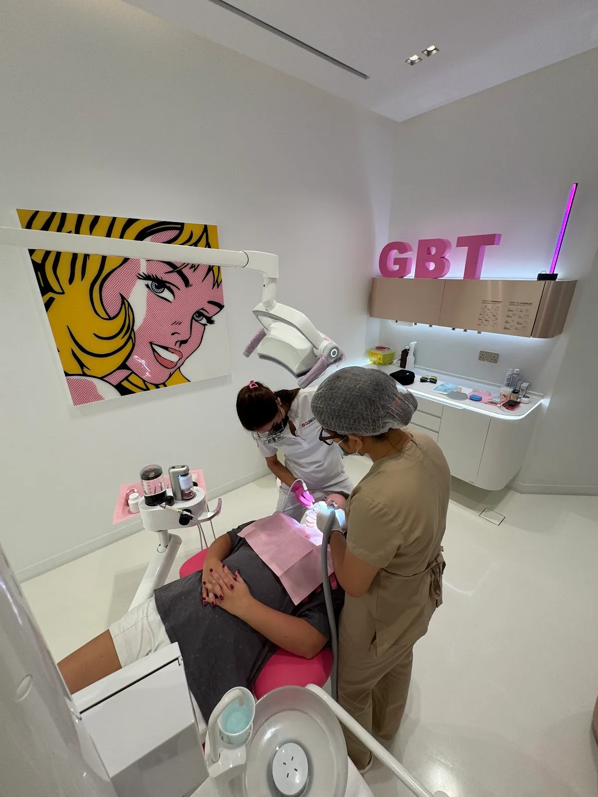 Patient receiving Guided Biofilm Therapy in a treatment room marked GBT