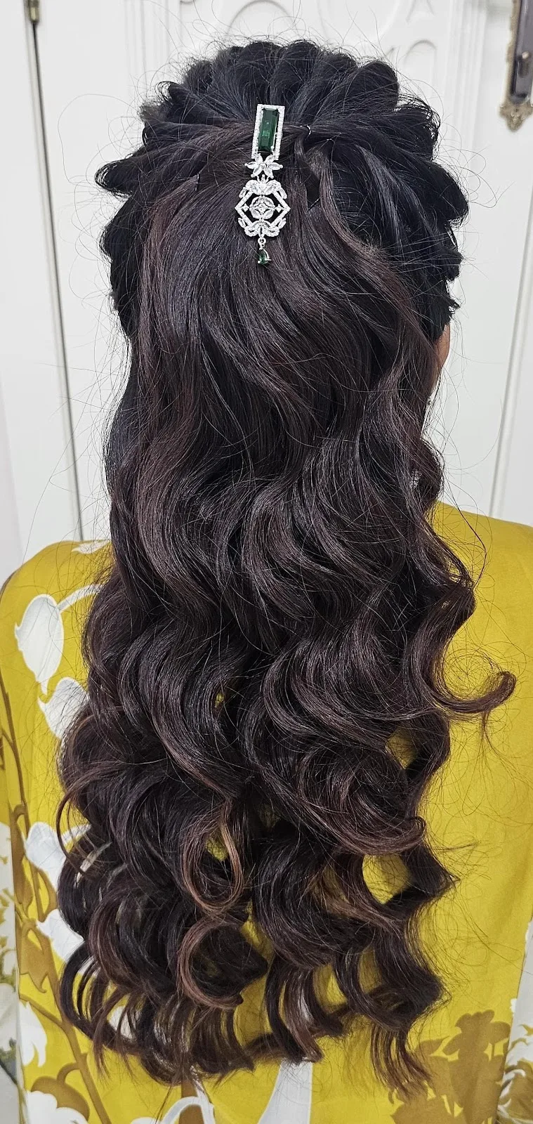 Long dark curls styled with a jewelled hair clip