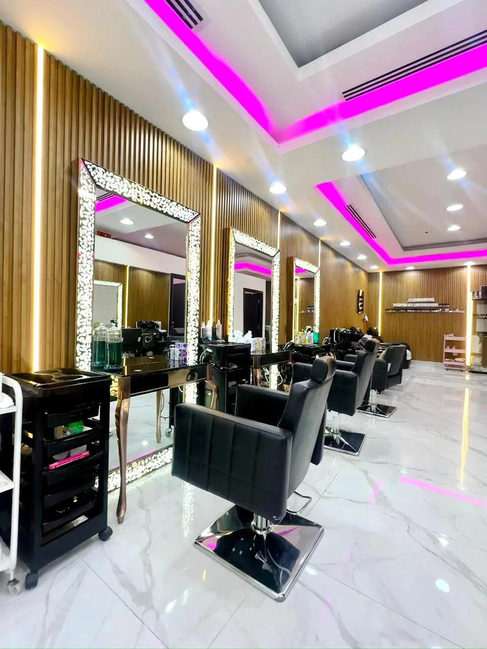 Inside Streaks Salon — styling chairs and lit mirrors along a wood-panelled wall