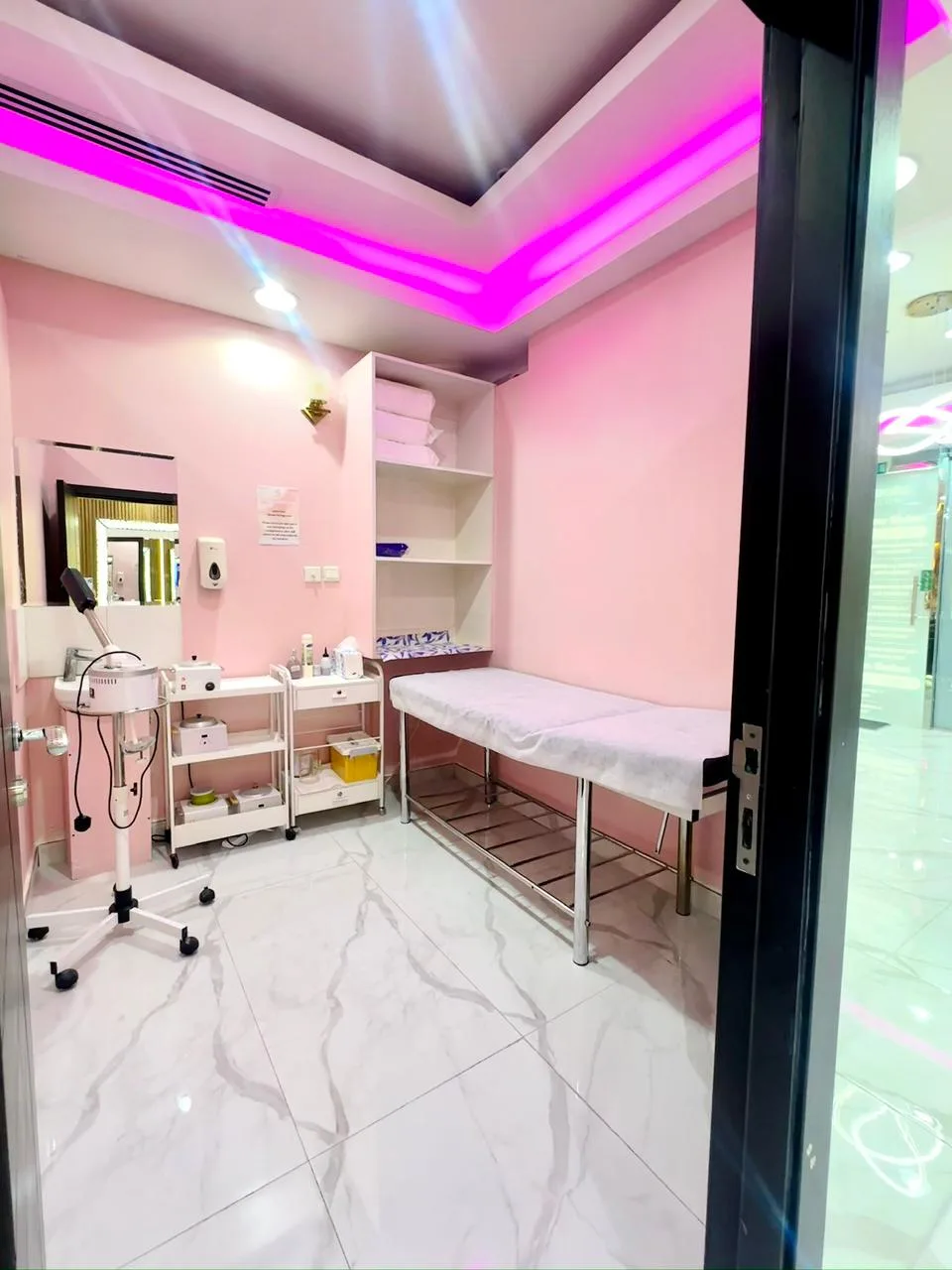 Calm pink facial and treatment room with a bed