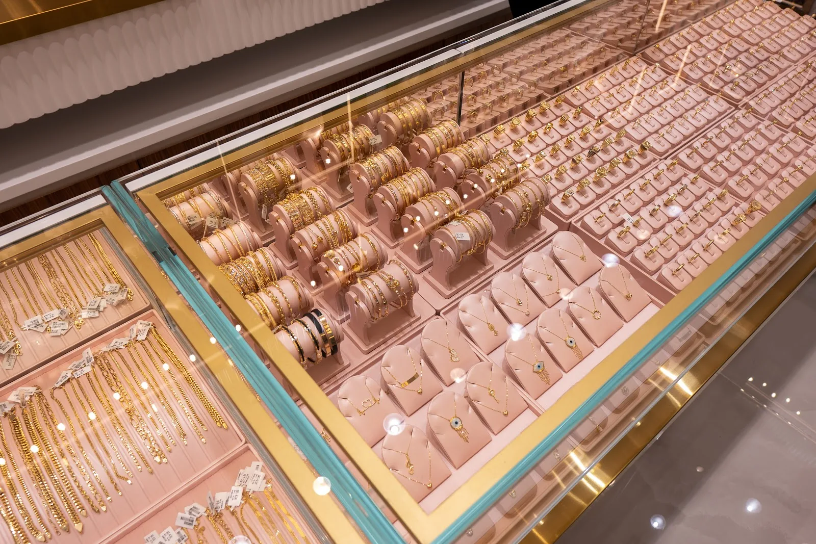 Gold chains and bracelets in a pink-lined display case