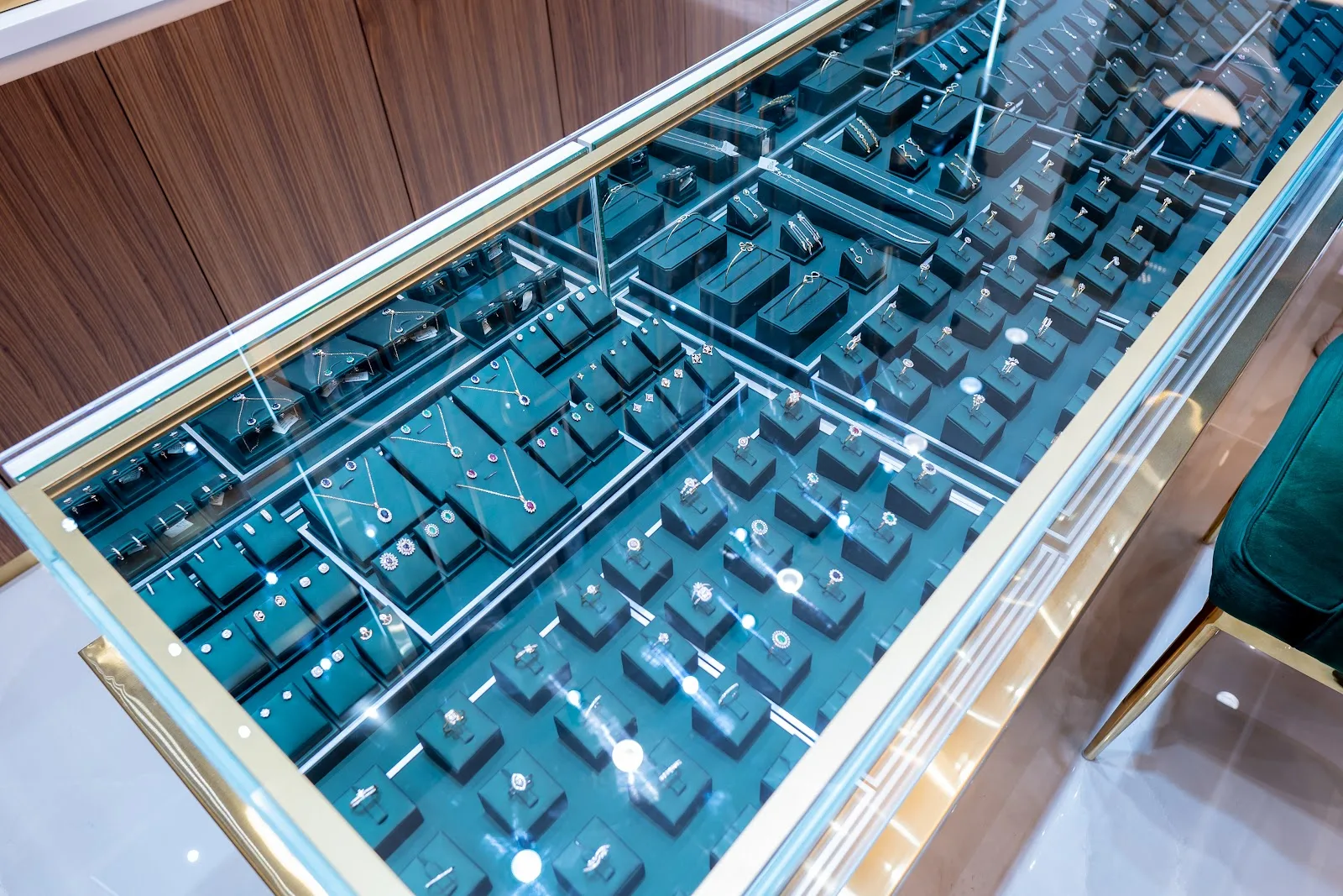Glass case of fine diamond rings and pendants on dark display blocks