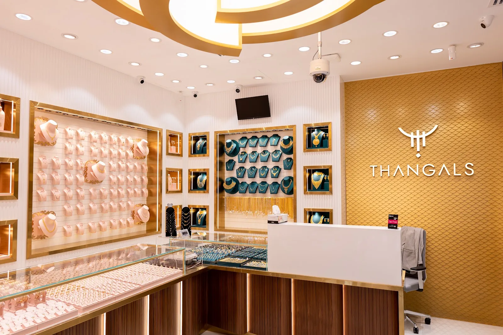 Interior of Thangals Jewellery showing gold display cases and the THANGALS emblem on the boutique wall