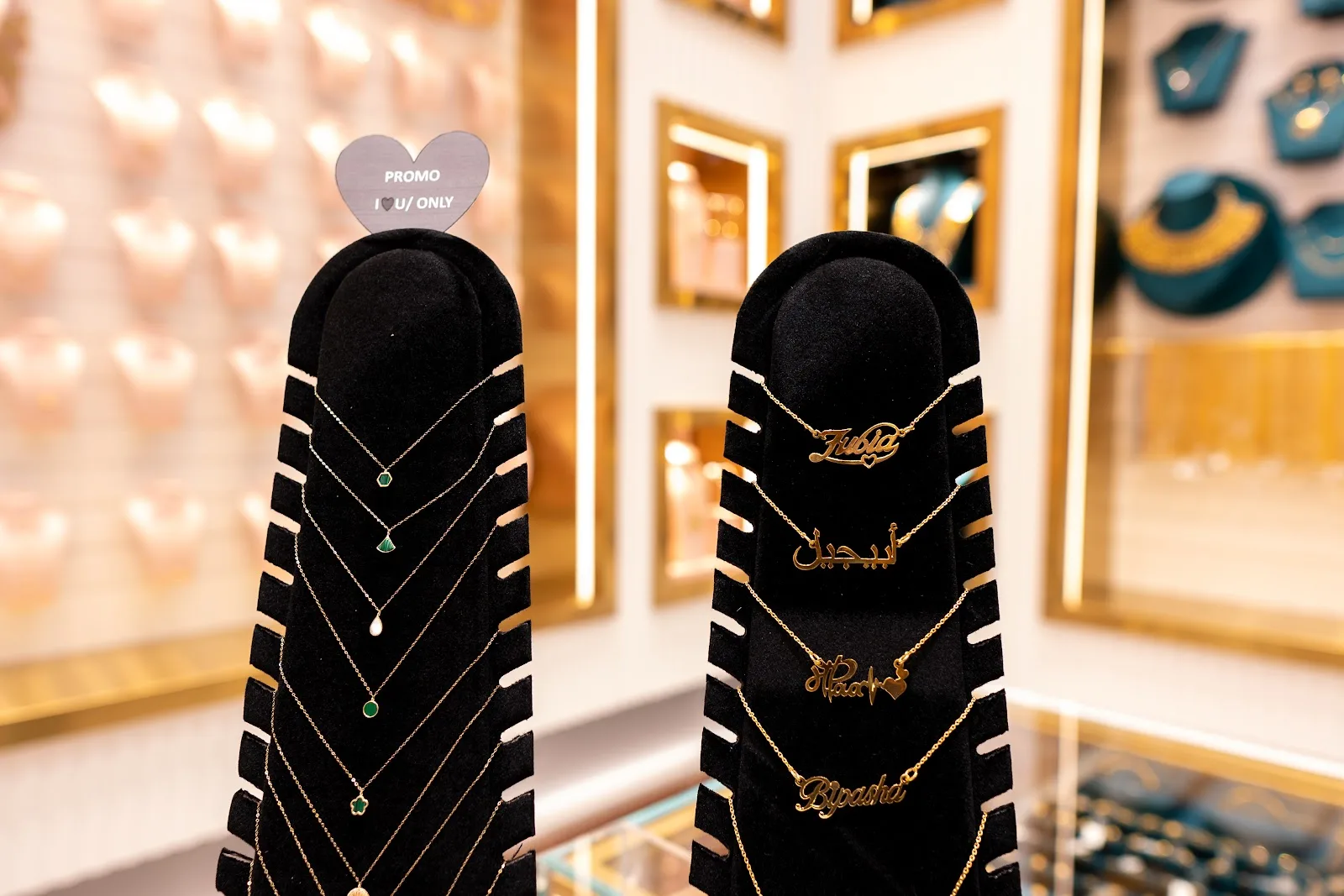 Personalised name necklaces in English and Arabic on display stands
