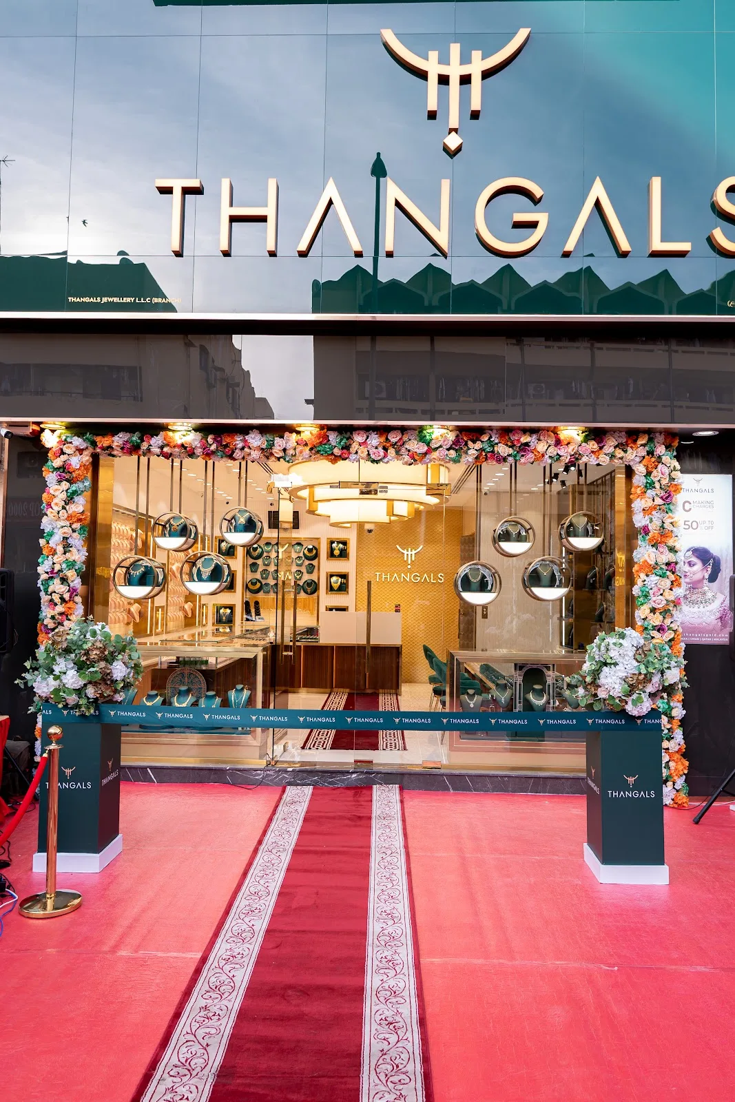 Thangals storefront entrance decorated with flowers and a red carpet