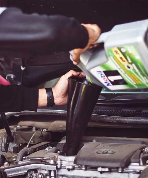 Fresh engine oil being poured during a service