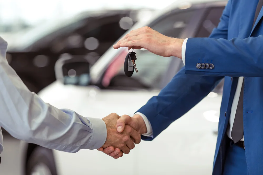 A set of car keys being handed back to a customer
