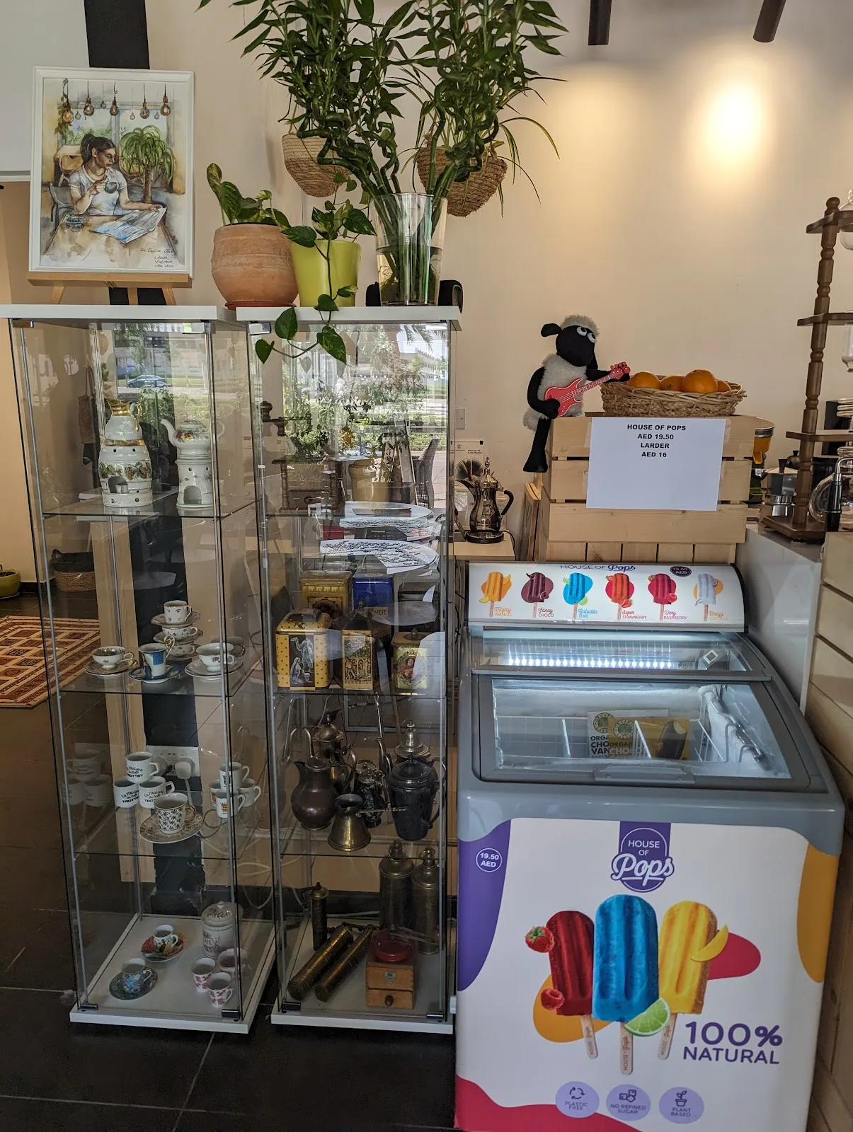 Glass cabinet of vintage teacups and a House of Pops freezer of natural ice pops