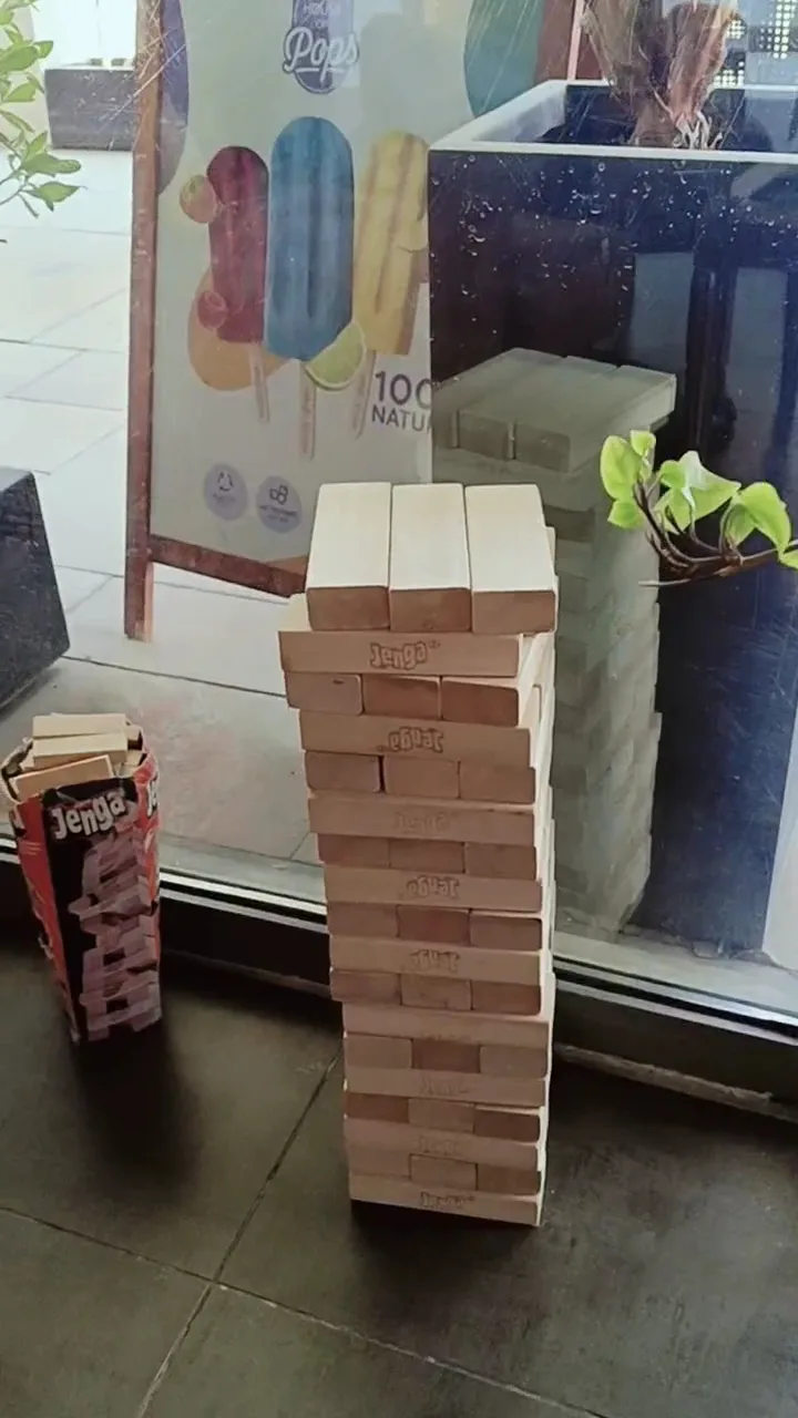 A tall tower of giant Jenga blocks set up by the café window