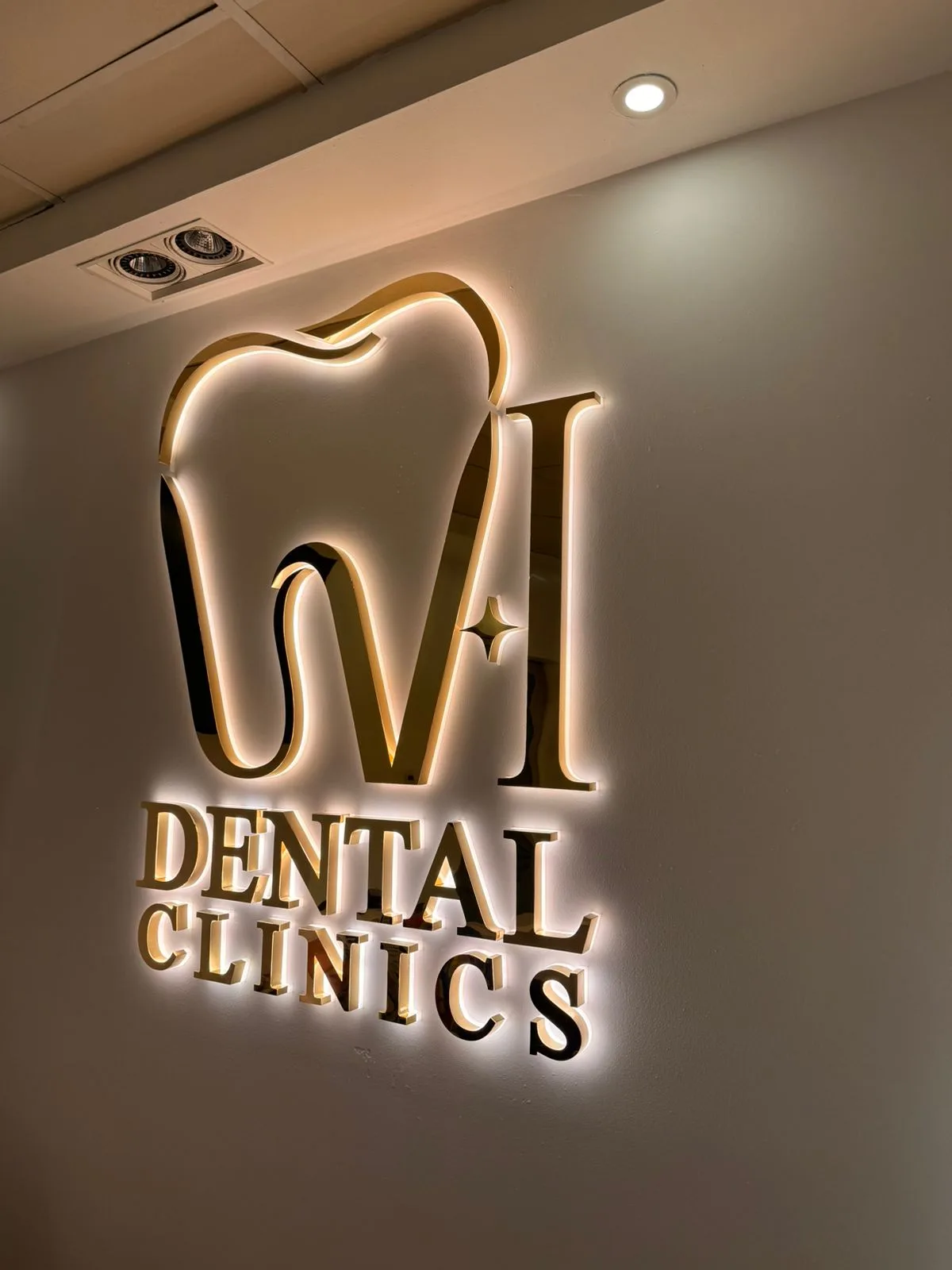 Polished brushed-gold backlit built-up lettering installed on an interior clinic wall